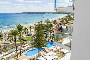 Un resort con piscina, playa y palmeras.