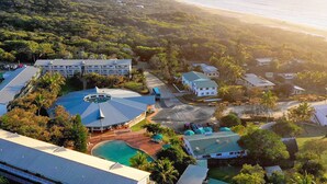 A resort with a pool, a large building with a circular roof, and a beach view. - K'gari Beach Resort (Eurong)