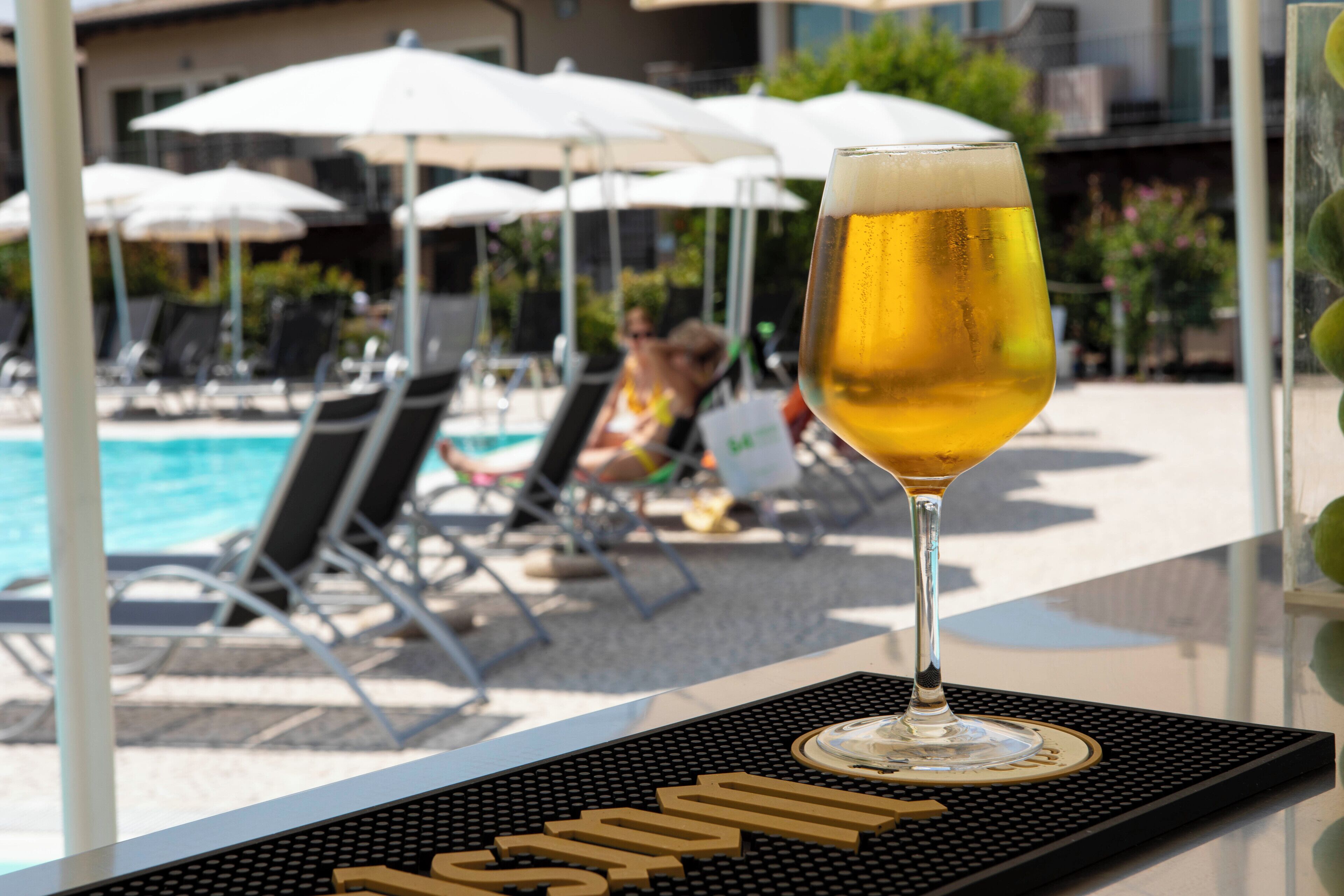 A glass of beer on a bar mat with the word "pool" visible.