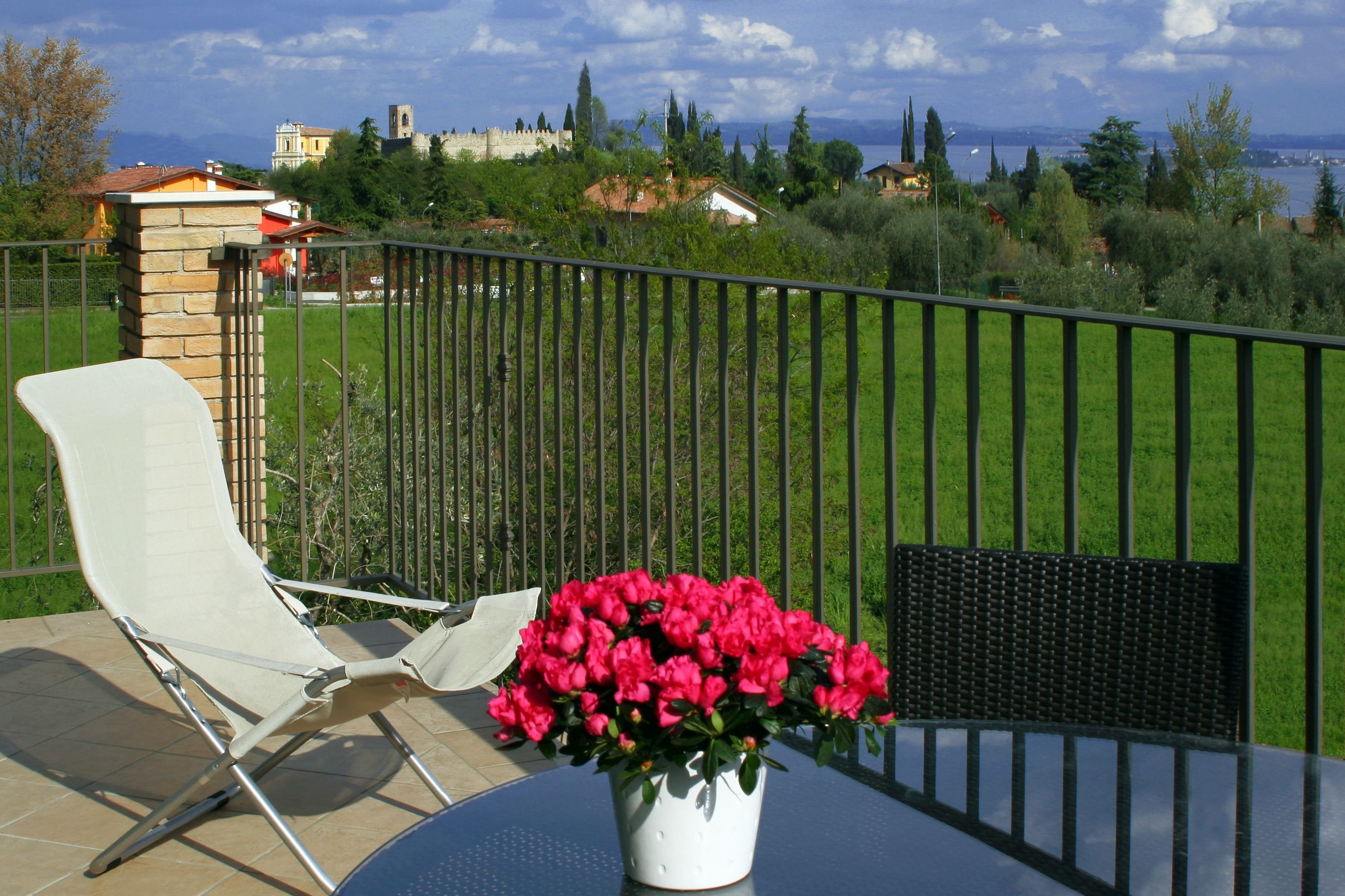 A patio with a table, a chair, and a potted plant.