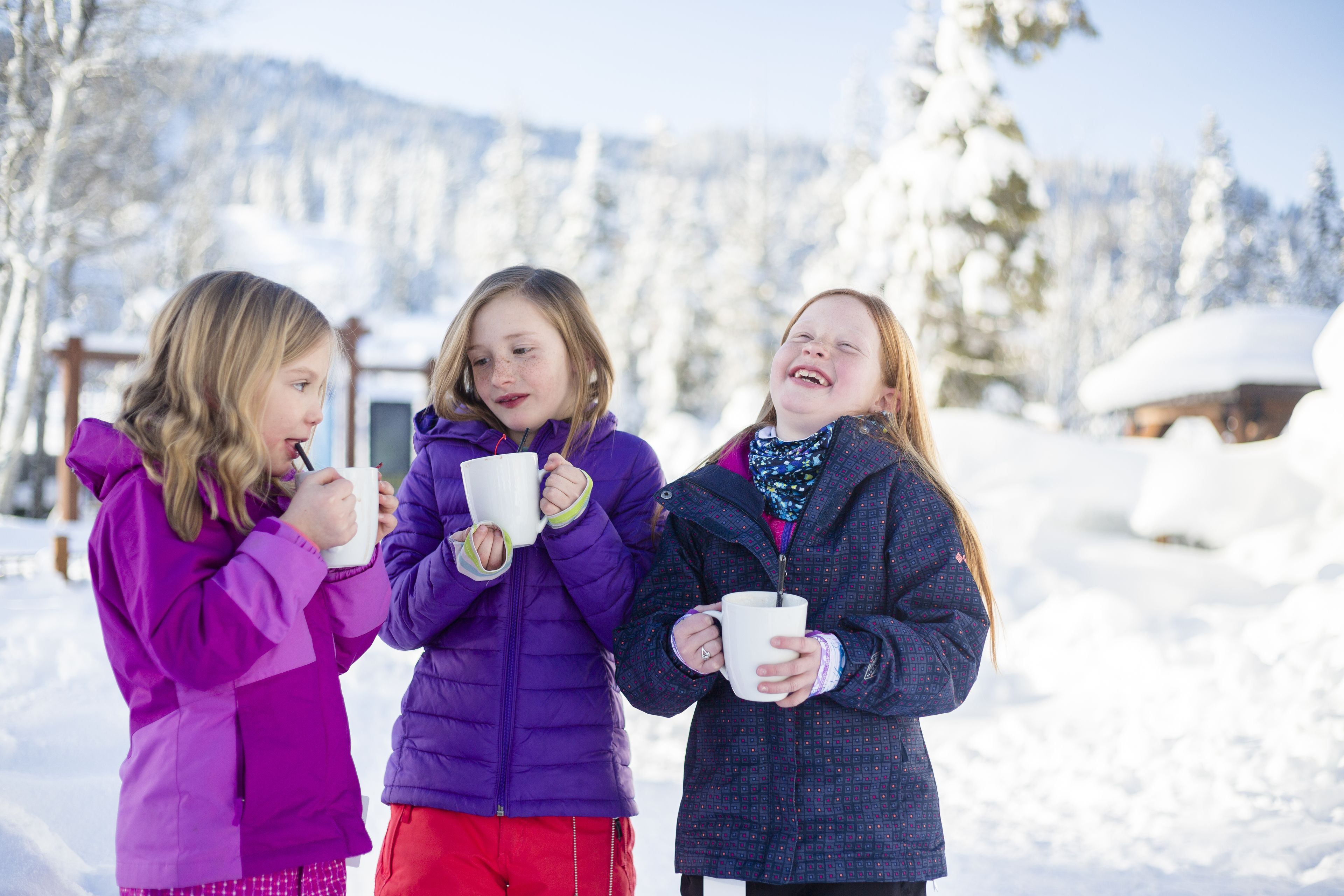 Three people standing outdoors in a snowy environment.