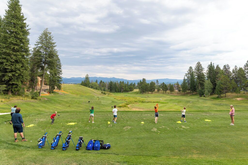 A golf course with players and bags.
