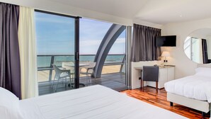 A hotel room with a bed, a desk, a chair, a TV, and a balcony with a view of the sea. - Kursaal Hotel (Cattolica)