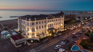 A hotel with a balcony, located near a beach and a parking area. - Kursaal Hotel (Cattolica)