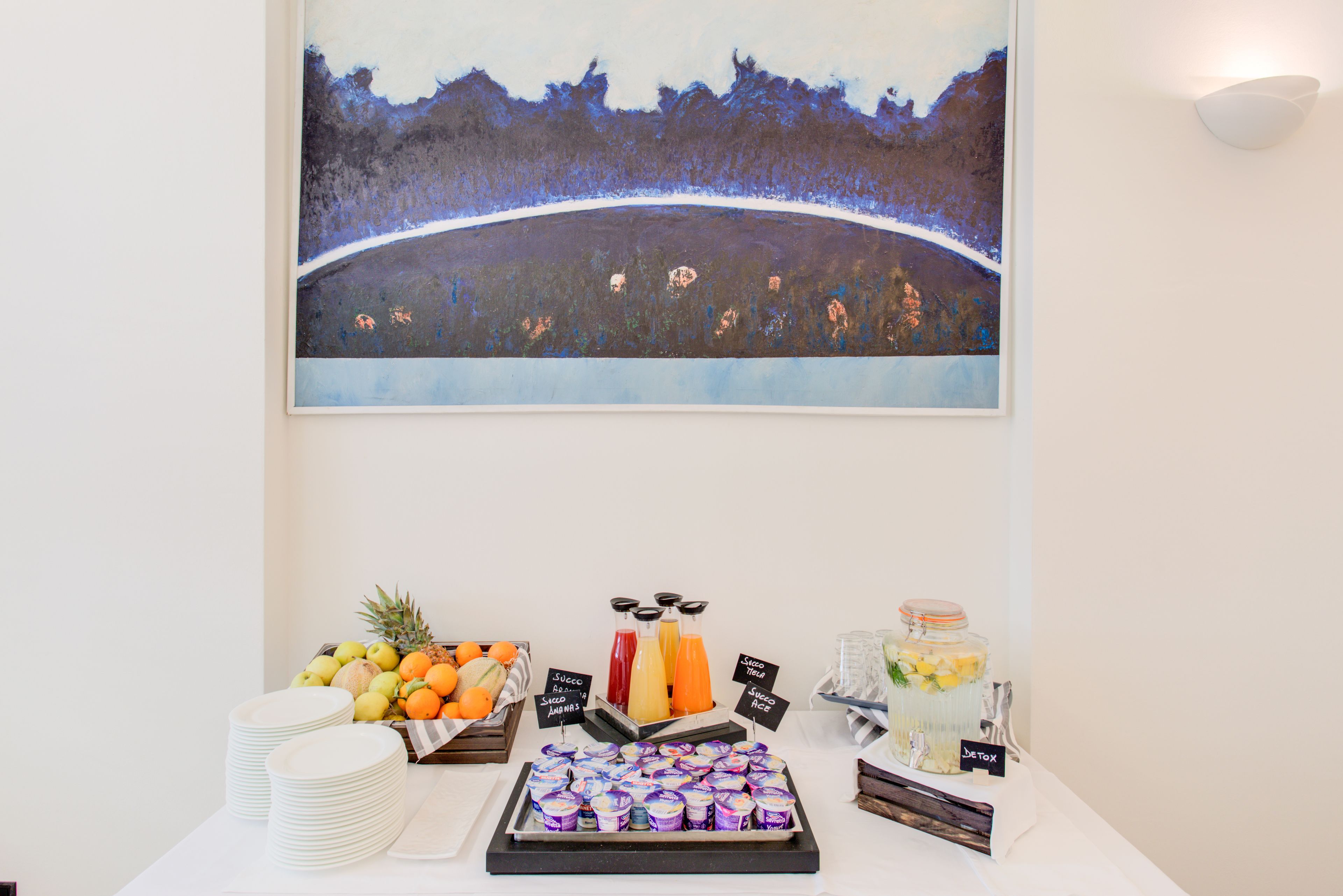 A buffet table with fruits, juices, and yogurt parfaits.