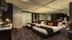 Un dormitorio moderno con una cama grande, un escritorio y un espejo.
