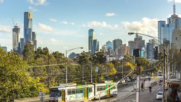 A cityscape with modern buildings, a tram, and a clear sky.