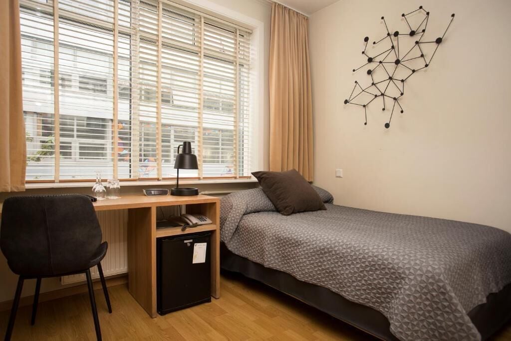 Une chambre à coucher avec un lit, un bureau et une chaise.
