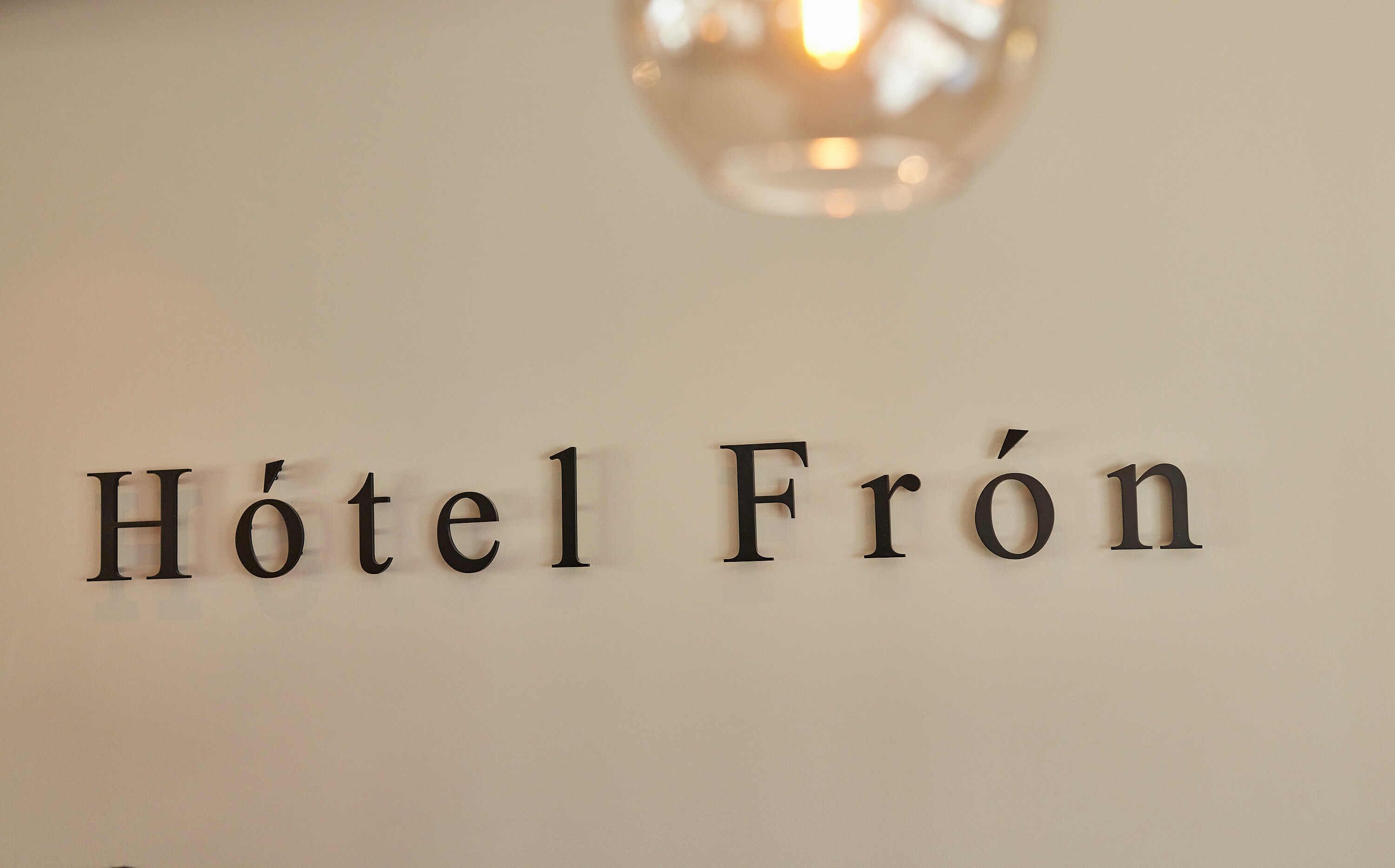 Une enseigne portant l’inscription « Hôtel Fron », indiquant le nom d’un hôtel.
