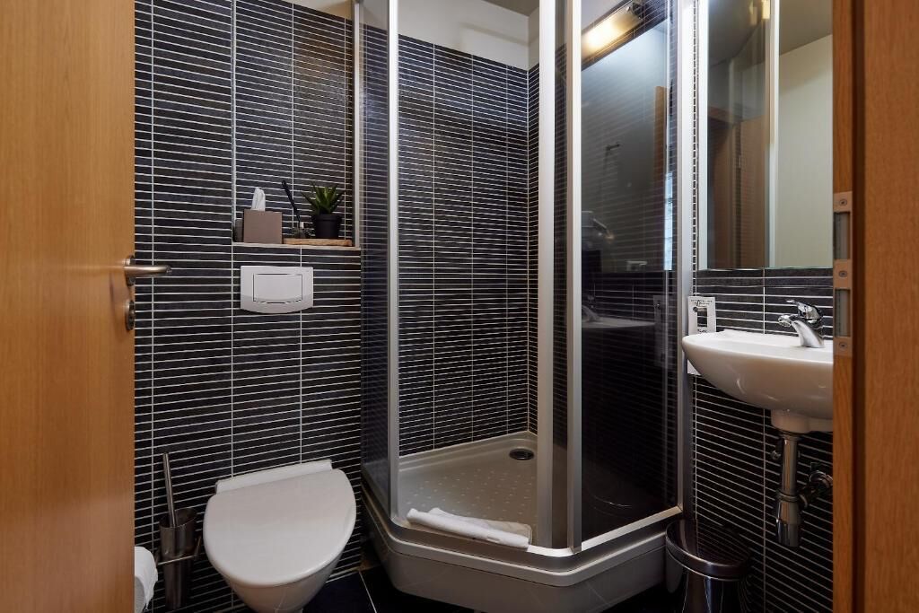 Un baño con ducha, inodoro y lavamanos.