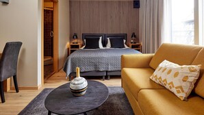 A modern bedroom with a bed, a sofa, a chair, and a small table. - Hotel Fron (Reykjavik)