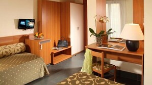 A hotel room with a bed, a desk with a lamp, a chair, a TV, and a wardrobe. - Ciampino Hotel (Ciampino)