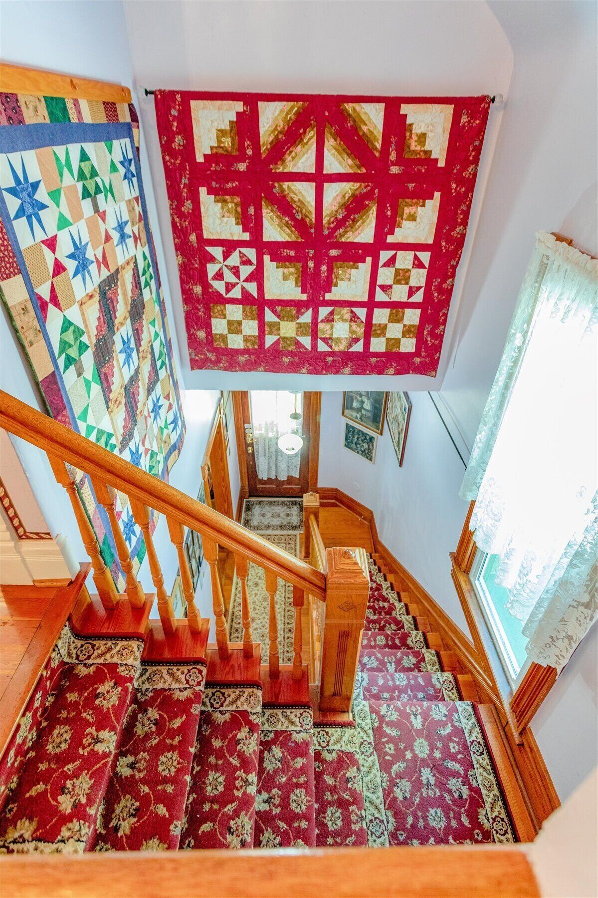 A staircase with wooden railings and patterned carpets.
