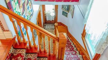 A staircase with wooden railings and patterned carpets.