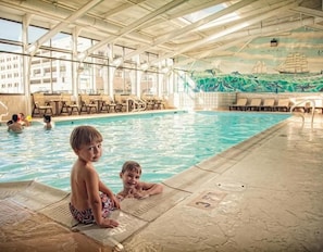 Ein Hallenbad mit gefliestem Boden und Wandgemälde.