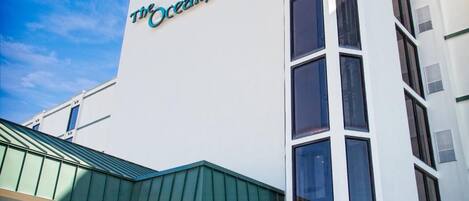 Un hotel llamado "The Oceanfront Inn" con un diseño moderno, ventanas amplias y un techo verde.