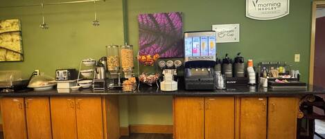 Una barra de desayuno con una máquina de café, dispensadores de cereales y un cartel que dice 'Morning Medley Breakfast'.