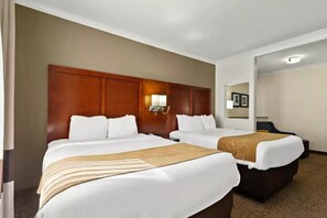 Une chambre d’hôtel avec deux lits, une tête de lit en bois, une table de chevet et une lampe fixée au mur.