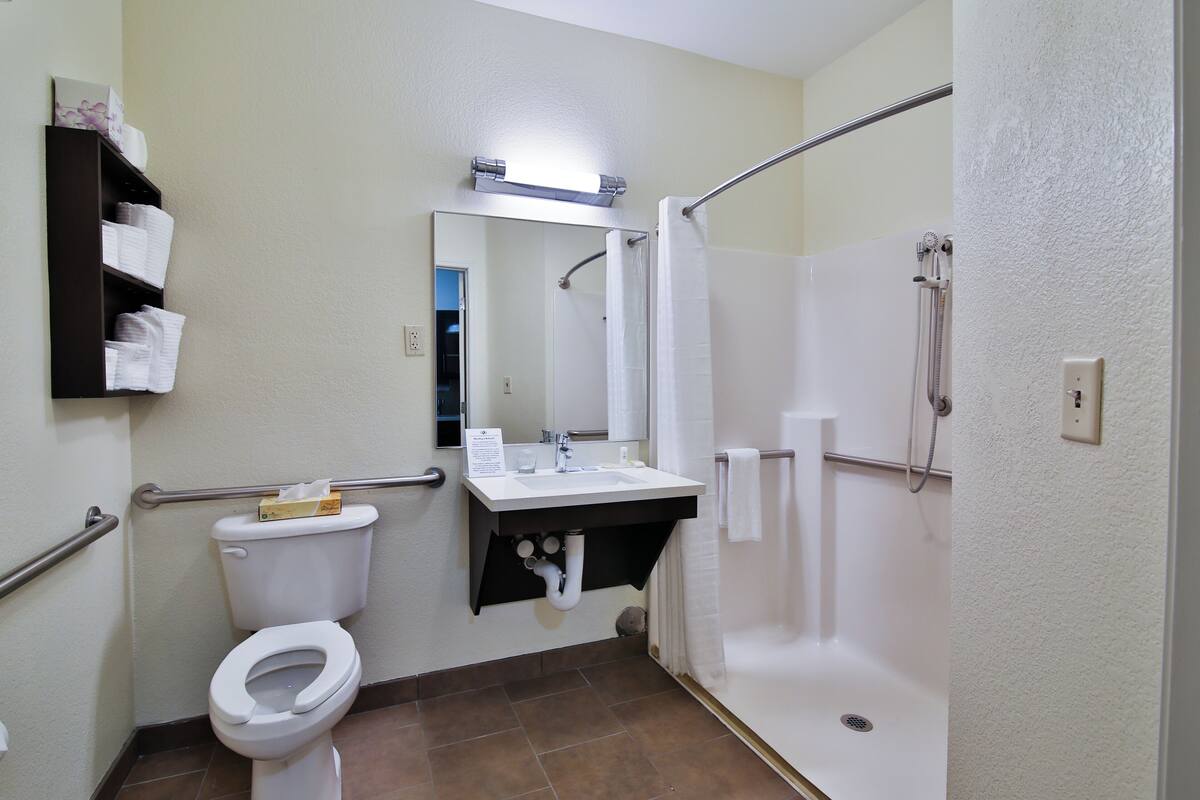A bathroom with a toilet, sink, and shower.