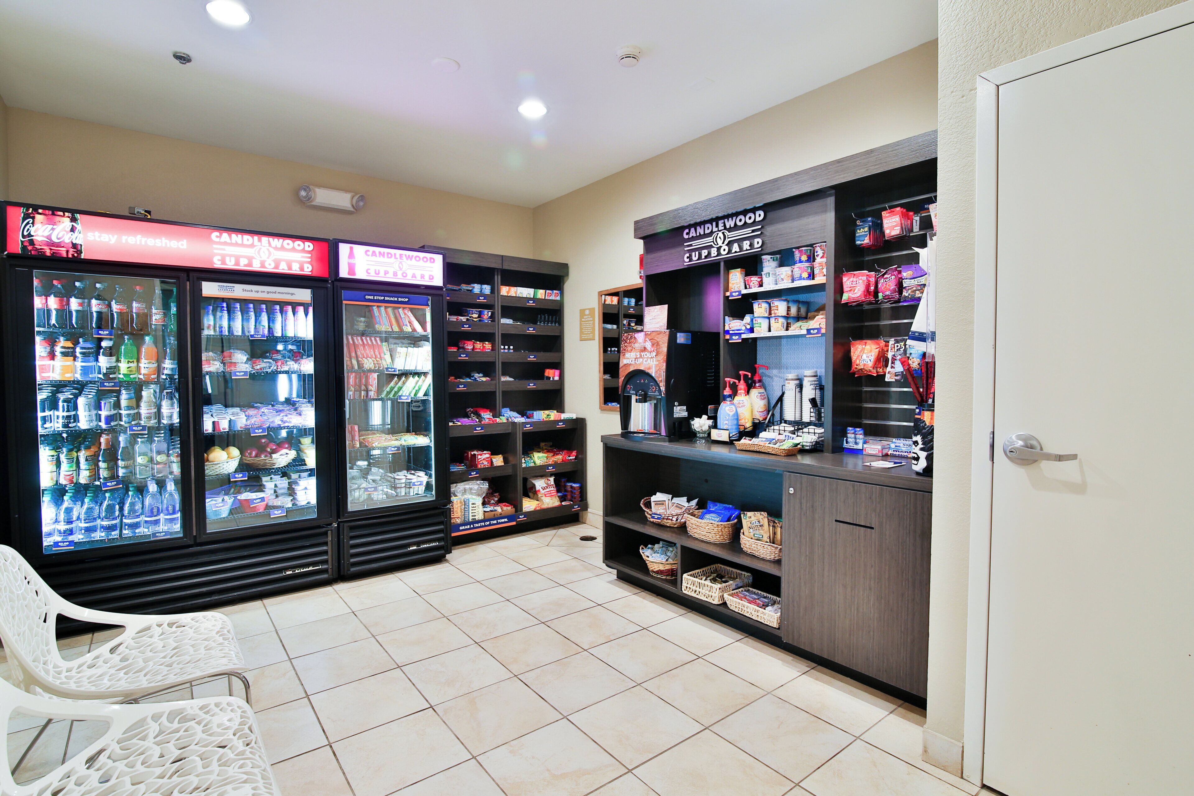 A convenience store with refrigerated beverage dispensers, snack shelves, and a section for personal care items.