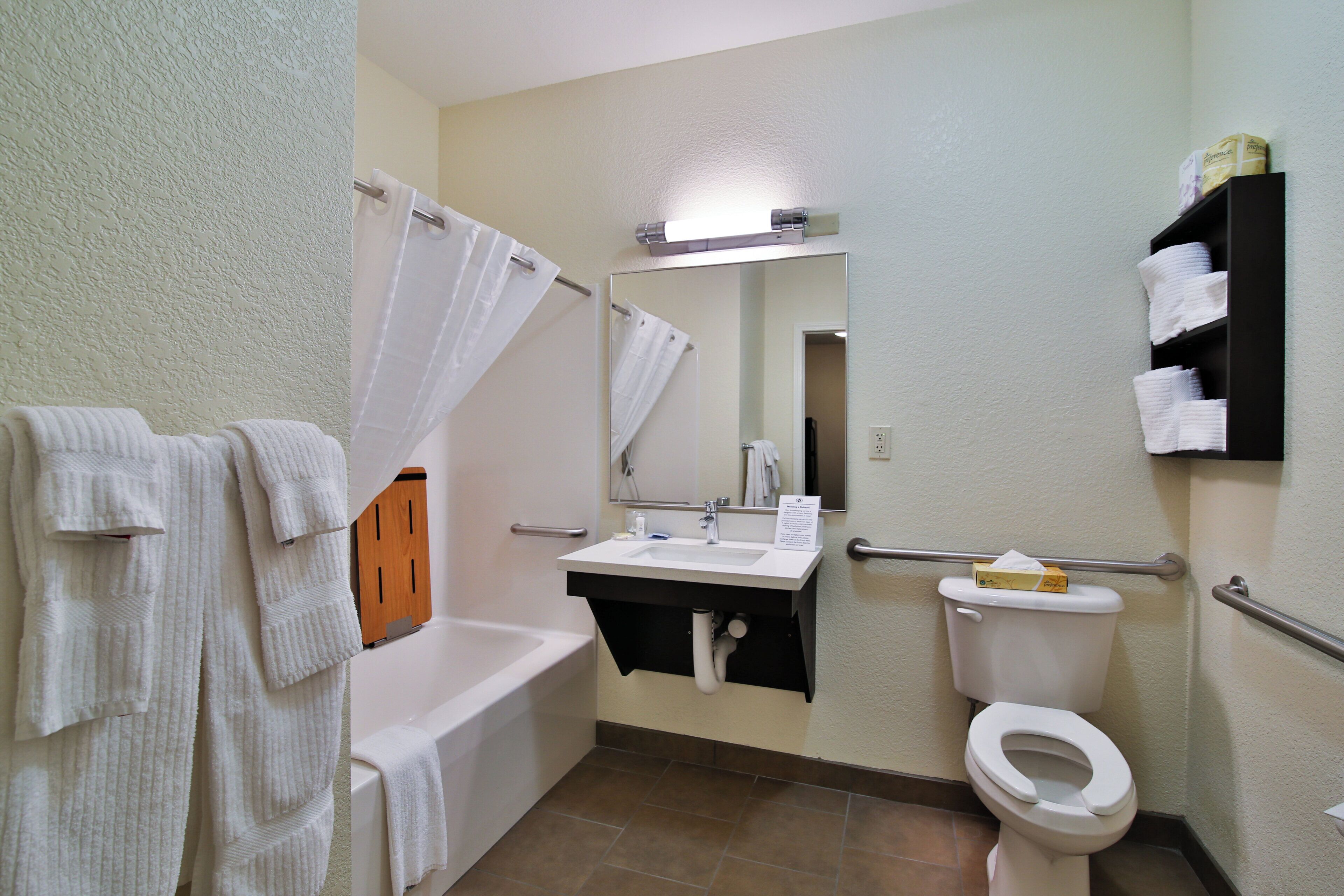 A bathroom with a bathtub, sink, toilet, and a mirror.