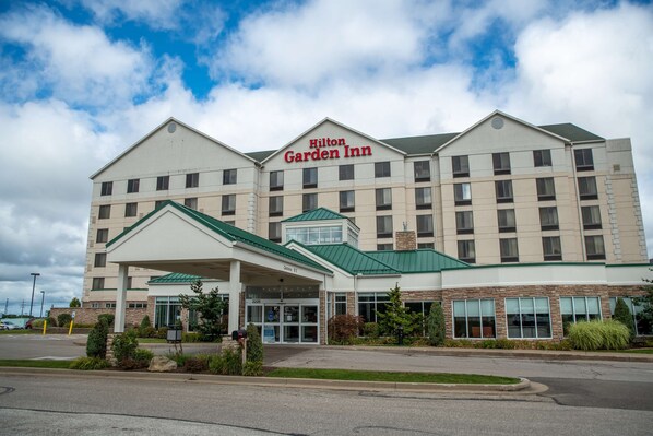 A Hilton Garden Inn with a modern design, featuring a prominent entrance and a covered parking area. - Hilton Garden Inn Erie (Erie)