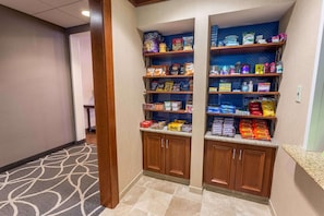 A hotel pantry with shelves stocked with snacks and beverages. - Hampton Inn & Suites Tilton (Tilton)