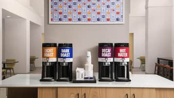 A coffee station with four dispensers labeled 'Light Roast,' 'Dark Roast,' 'Decaf Roast,' and 'Hot Water.'
