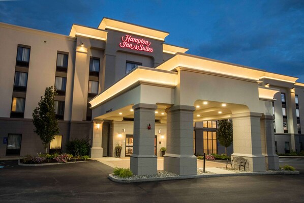 Un hôtel Hampton Inn & Suites doté d’une façade moderne, de grandes colonnes et d’une entrée bien éclairée.