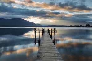 A wooden pier extending into calm water with mountains in the background. - ASURE Explorer Motel & Apartments (Te Anau)