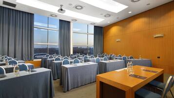 Una sala conferenze con diverse tavole, sedie e un grande tavolo di legno.