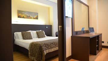 Ein Hotelzimmer mit einem Bett, einem Schreibtisch und einem großen Spiegel.