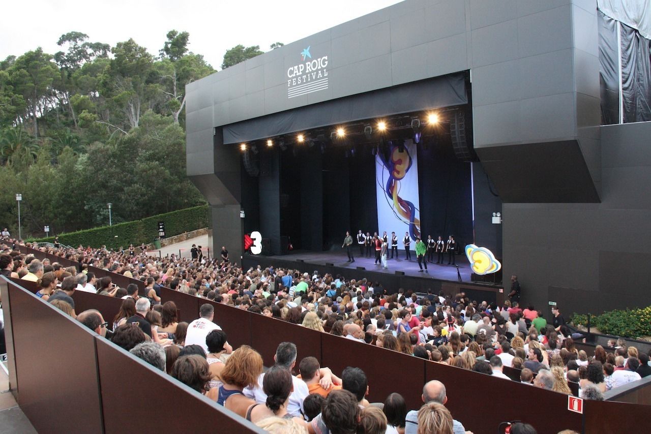 A large outdoor amphitheater with tiered seating, hosting a performance.