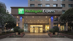 A Holiday Inn Express hotel entrance with a clear glass facade, a green and white logo, and a well-lit entrance area. - Holiday Inn Express Chengdu Gulou by IHG (Chengdu)