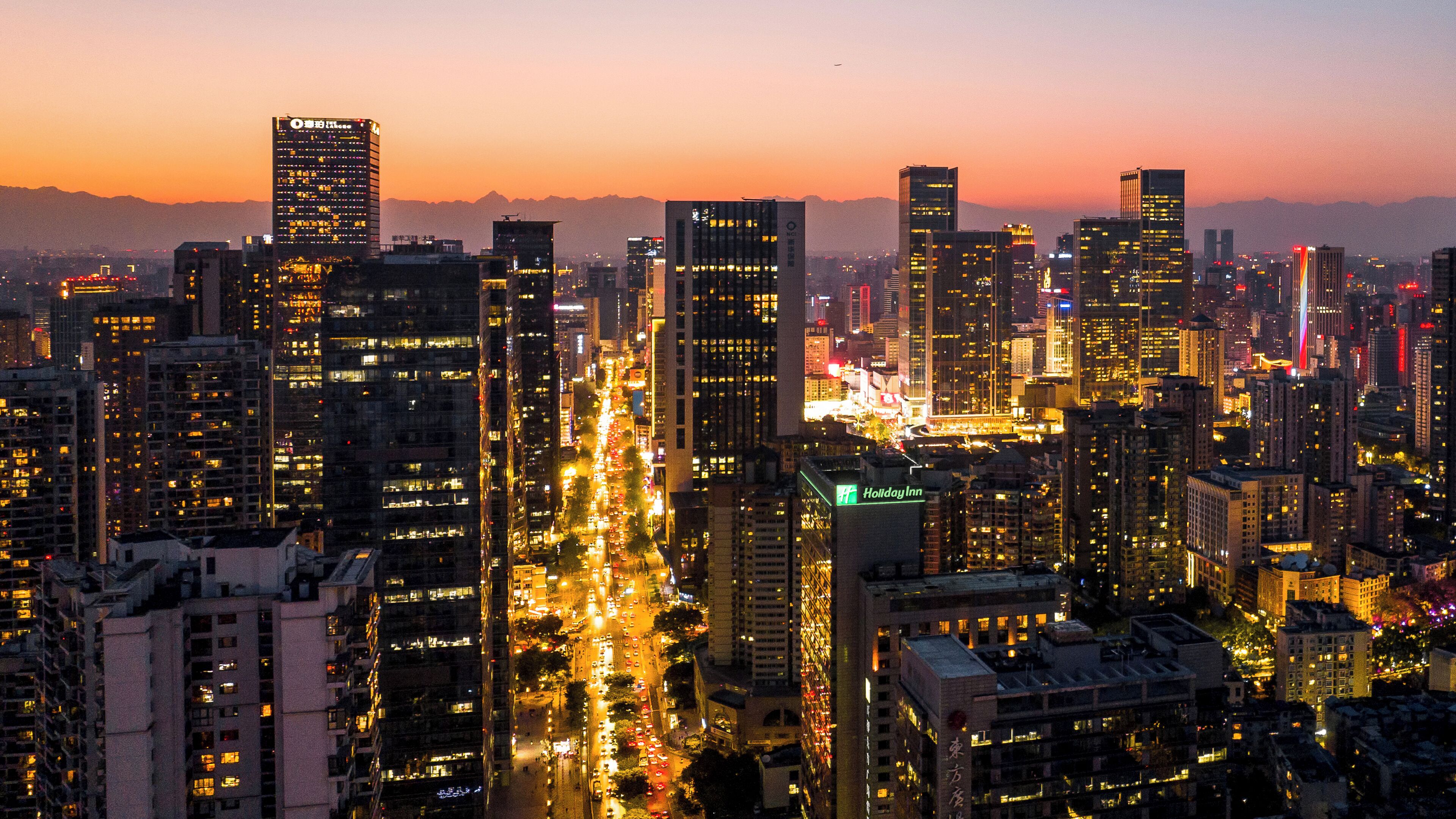 A cityscape with high-rise buildings, busy streets, and a prominent Holiday Inn hotel.