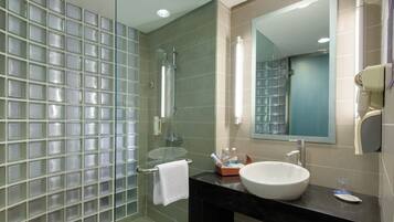 A modern bathroom with a glass shower enclosure, a white sink, and a large mirror.