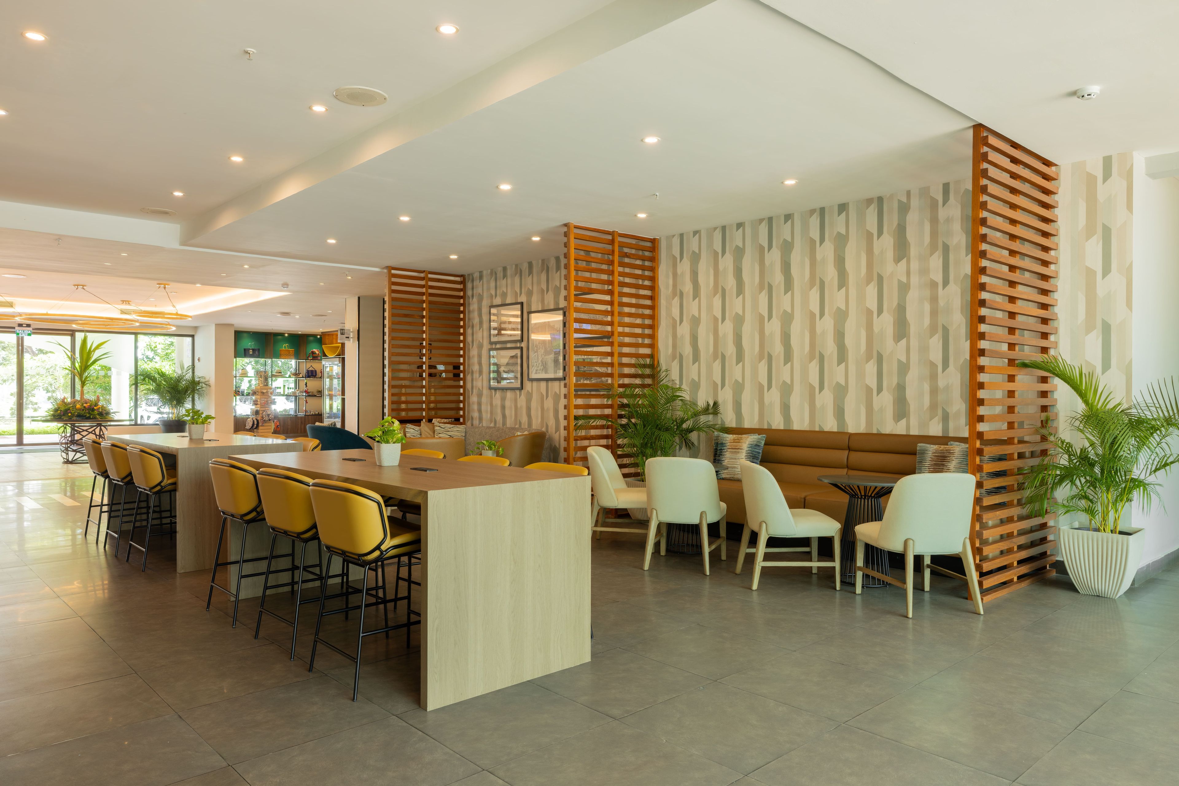 A modern interior with a central bar area, seating arrangements, and a patterned wall.
