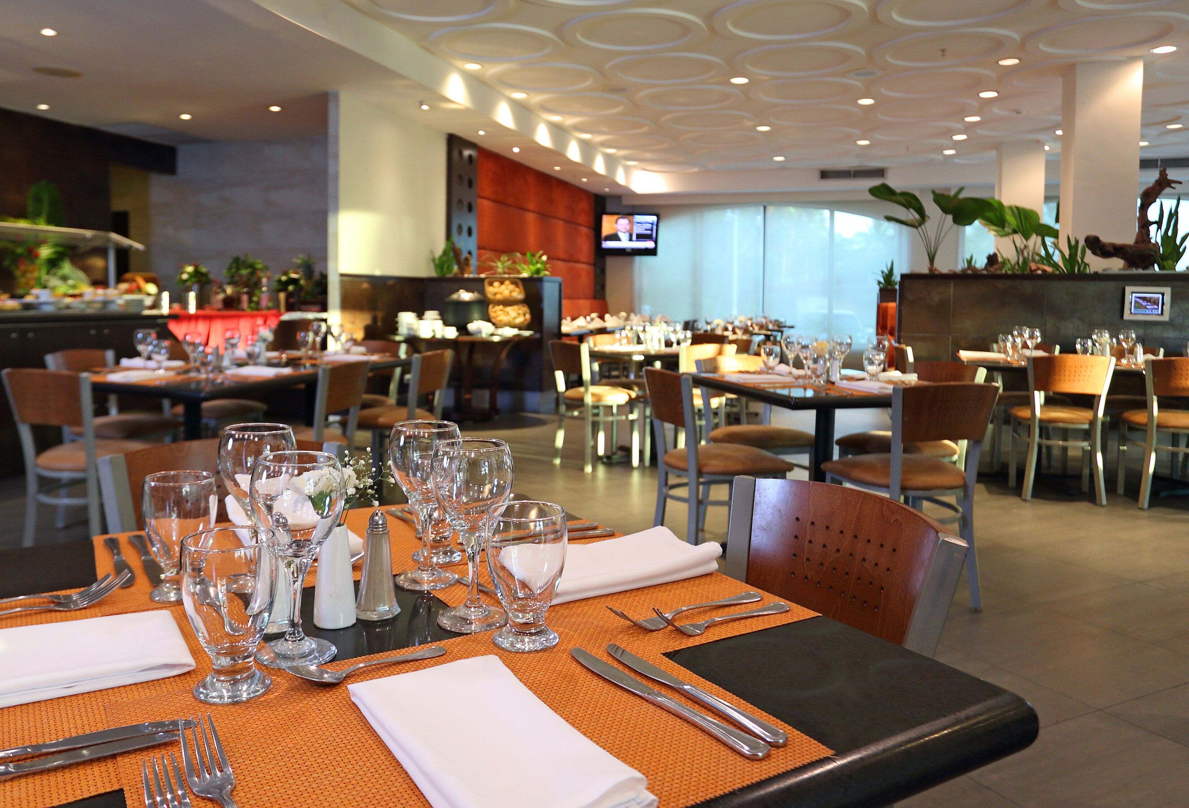 Ein Restaurant mit gedeckten Tischen, Besteck und Gläsern.