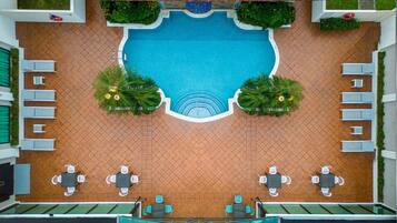 Alberca al aire libre, sombrillas en la alberca y camastros