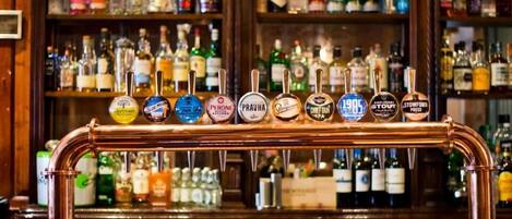 Een bar met een koperen biertap en verschillende andere bierkraaninstallaties, waaronder merken zoals Peroni en Stowford.