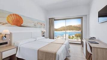A hotel room with two beds, a desk, a TV, and a large window with a beach view.