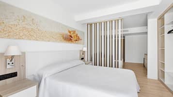 A modern bedroom with a bed, bedside tables, a wall-mounted lamp, and a large artwork.