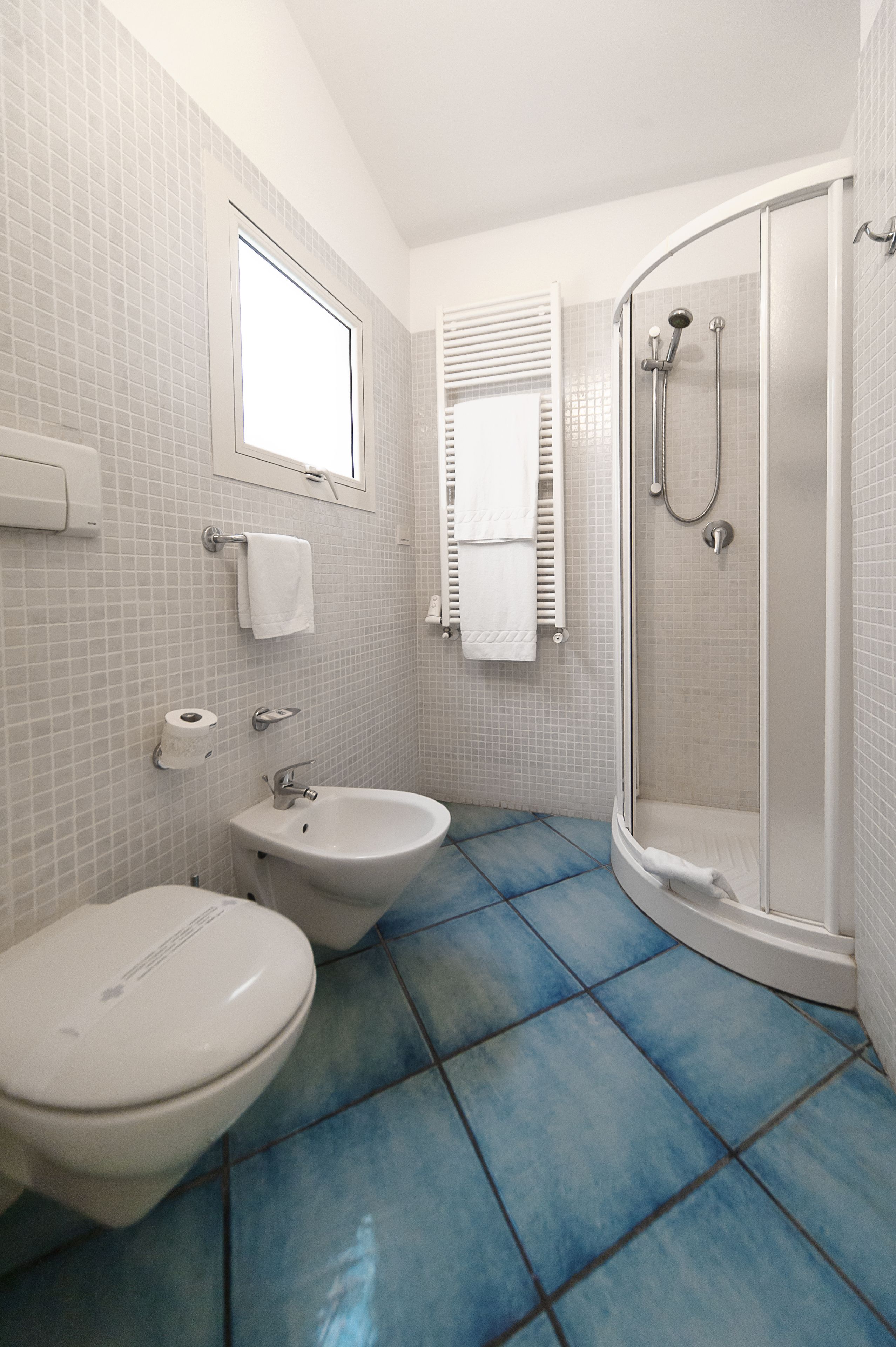 Ein Badezimmer mit Toilette, Bidet und einer Duschkabine.