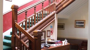 A staircase with wooden railings and green carpeted steps. - The Glen Guesthouse (Selkirk)