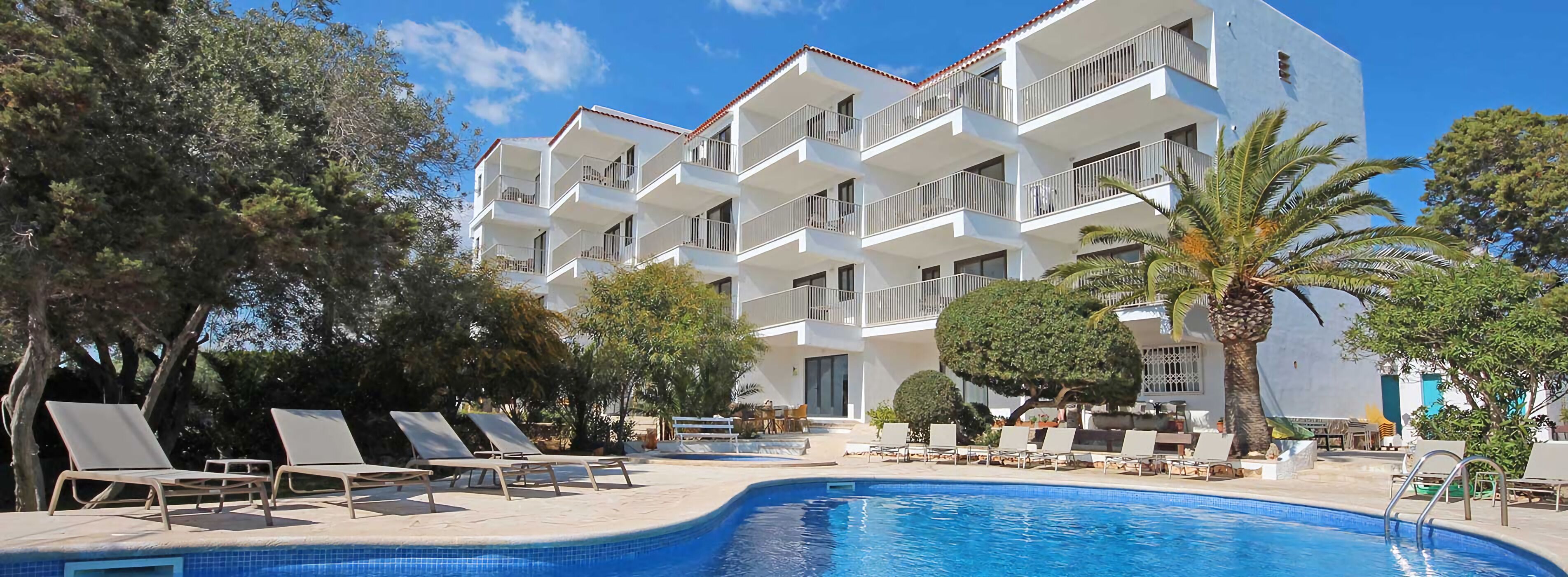 Un hotel con piscina, varios balcones y zonas de estar al aire libre.