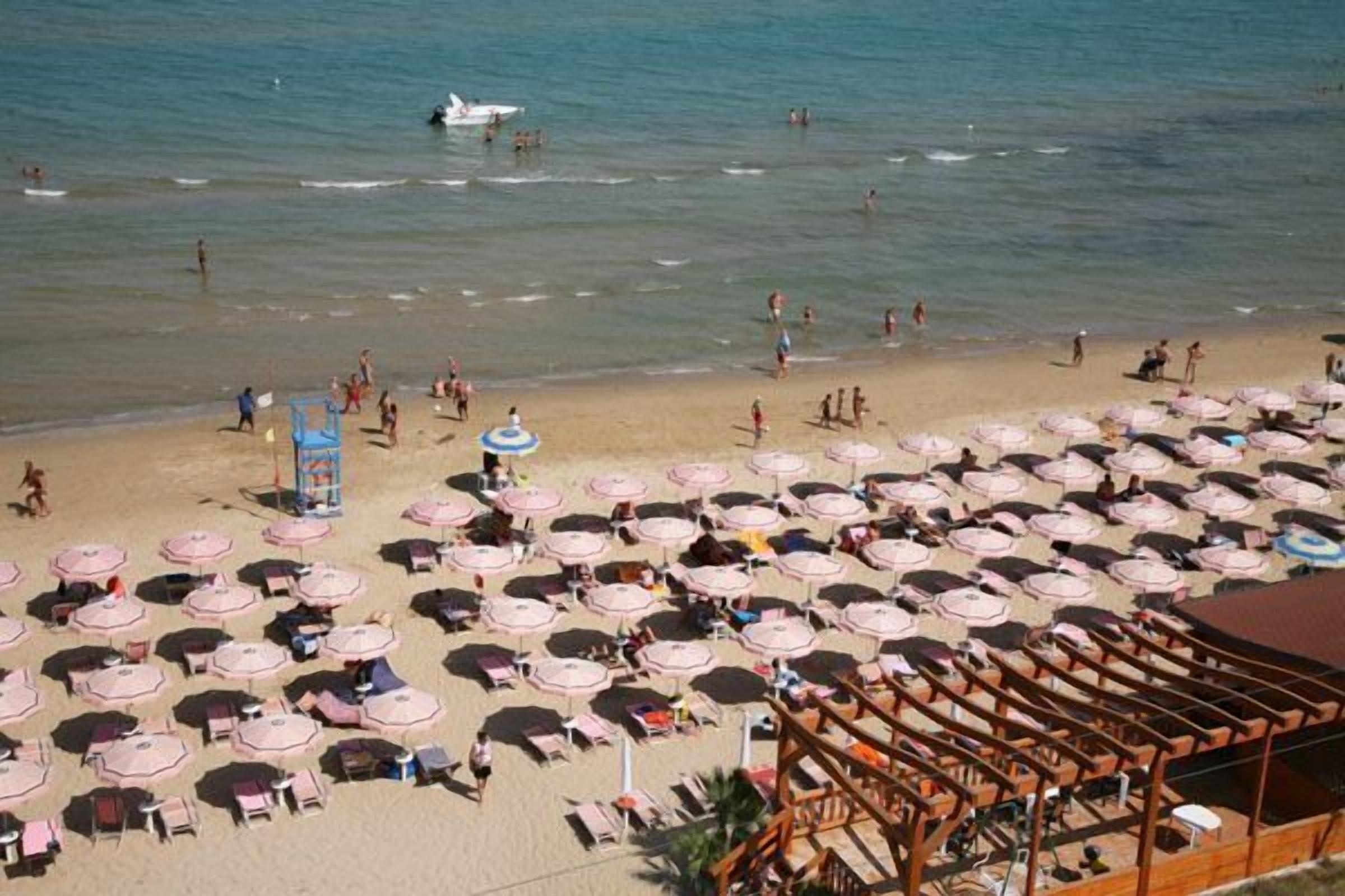 Privat strand, solstolar, parasoller och strandbarer