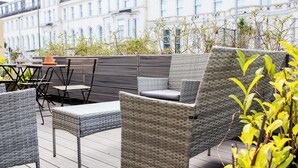 A rooftop patio with wicker furniture, a table, and chairs. - The Montana (Torquay)