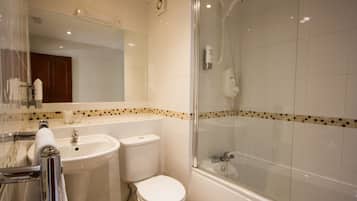 Un baño con lavamanos, inodoro y ducha con cerramiento de vidrio.