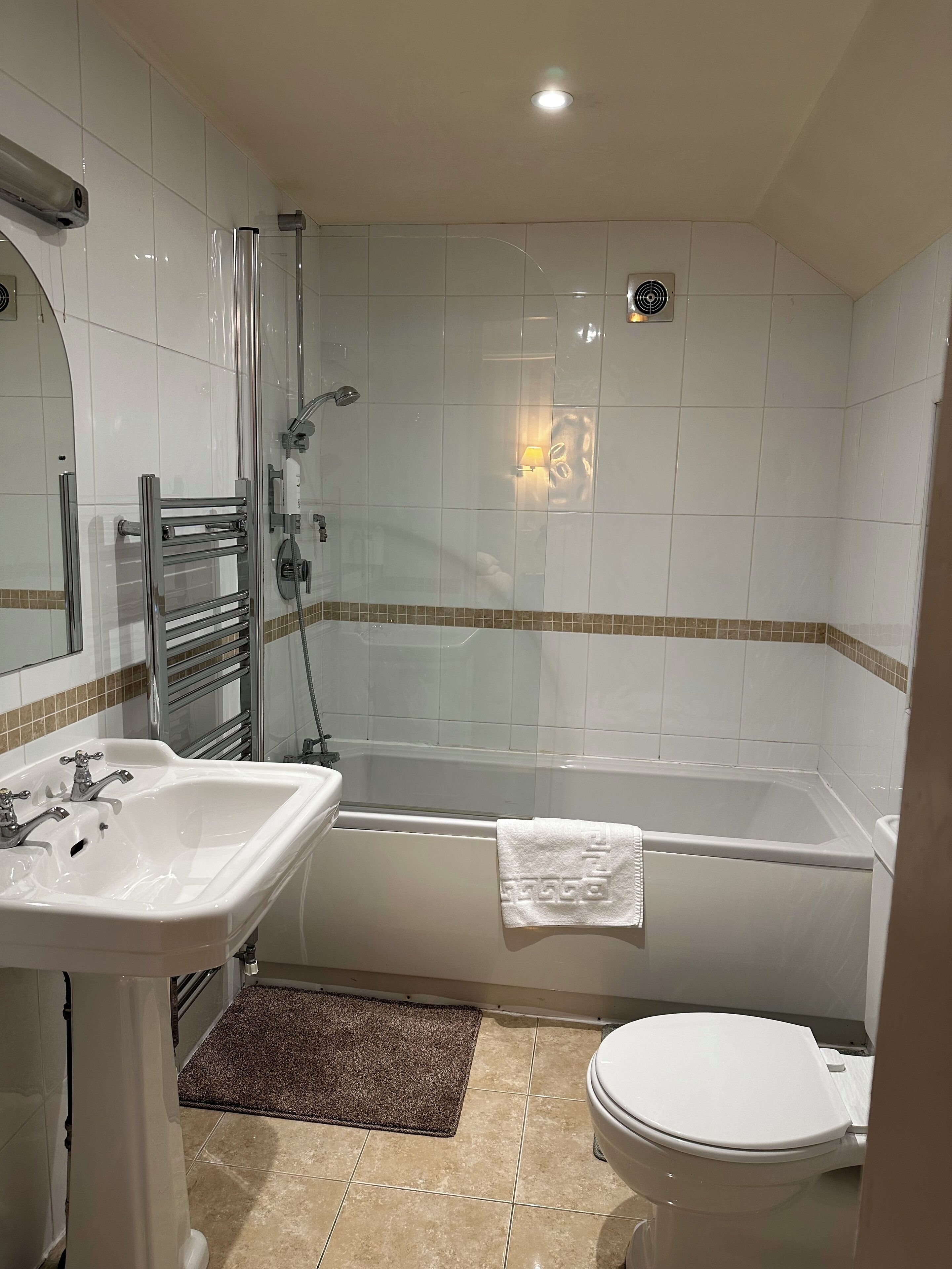 A modern bathroom with a bathtub, a sink, and a toilet.