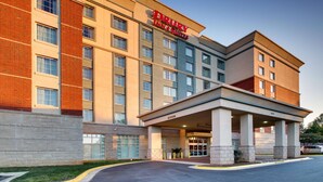 A Drury Inn & Suites building with a brick facade, multiple floors, and a covered entrance area. - Drury Inn & Suites Charlotte Northlake (Charlotte)